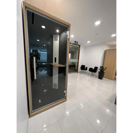 Cabine acoustique OneZone avec finition bois clair, installée dans un bureau lumineux au sol en céramique