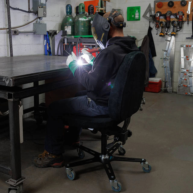 Synetik SF190 welding chair used at a workstation in a workshop