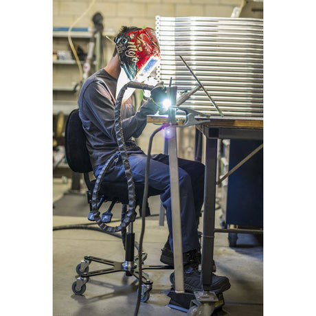 Personne effectuant un travail de soudure en position assise sur une chaise Synetik SF180 Soudure.